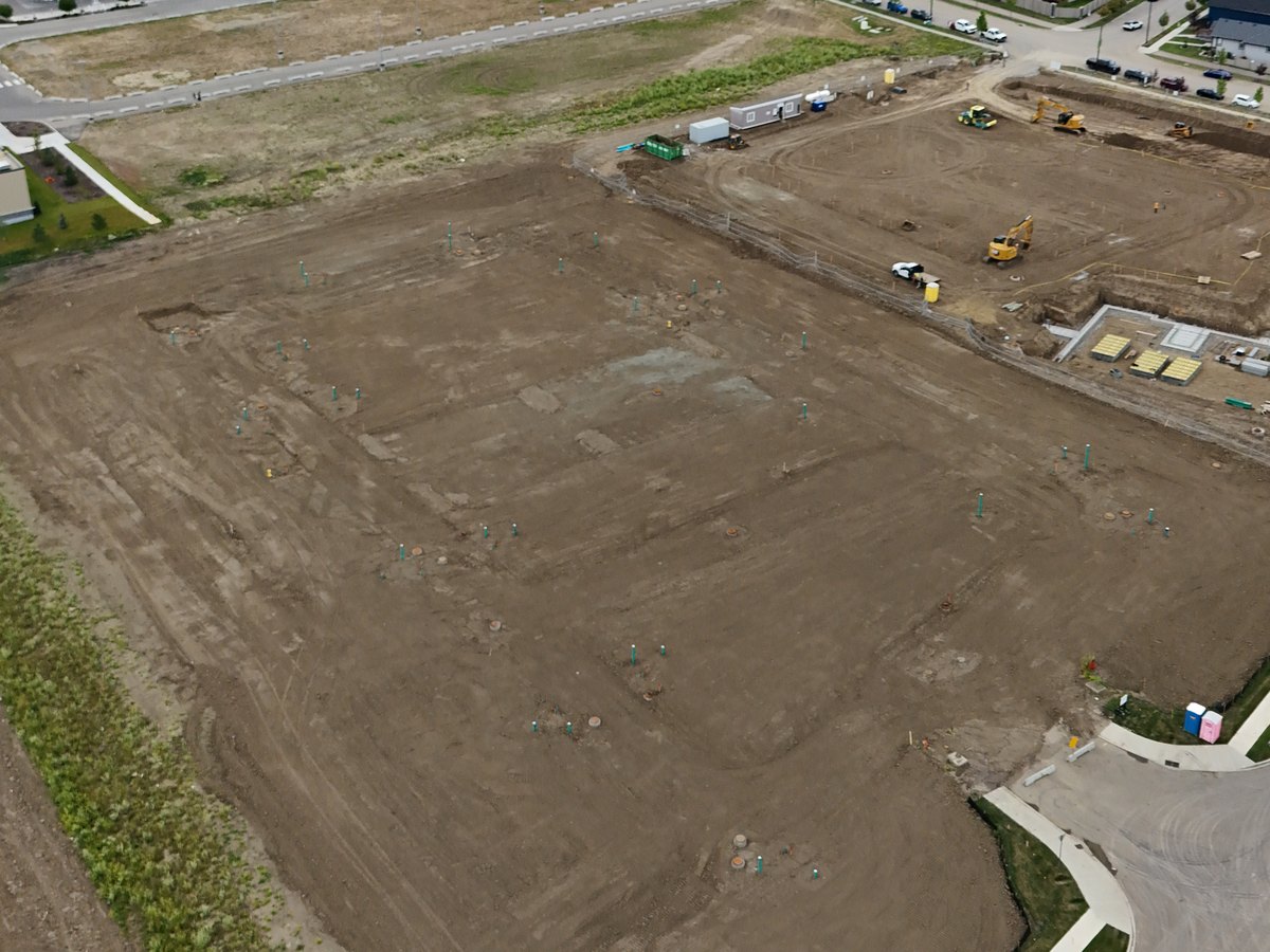 Graded development land with survey stakes marking the site layout near Leduc