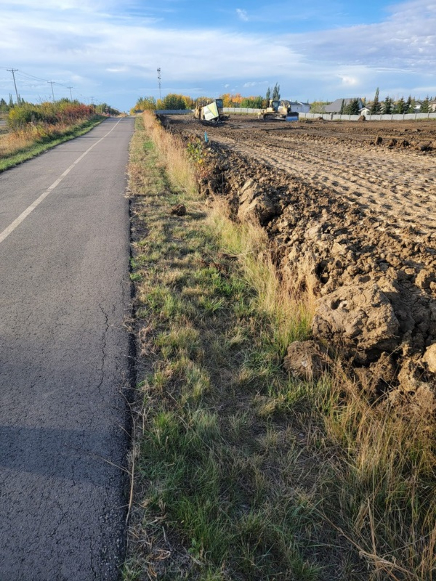 Roadside drainage ditch conveying stormwater on an Alberta site
