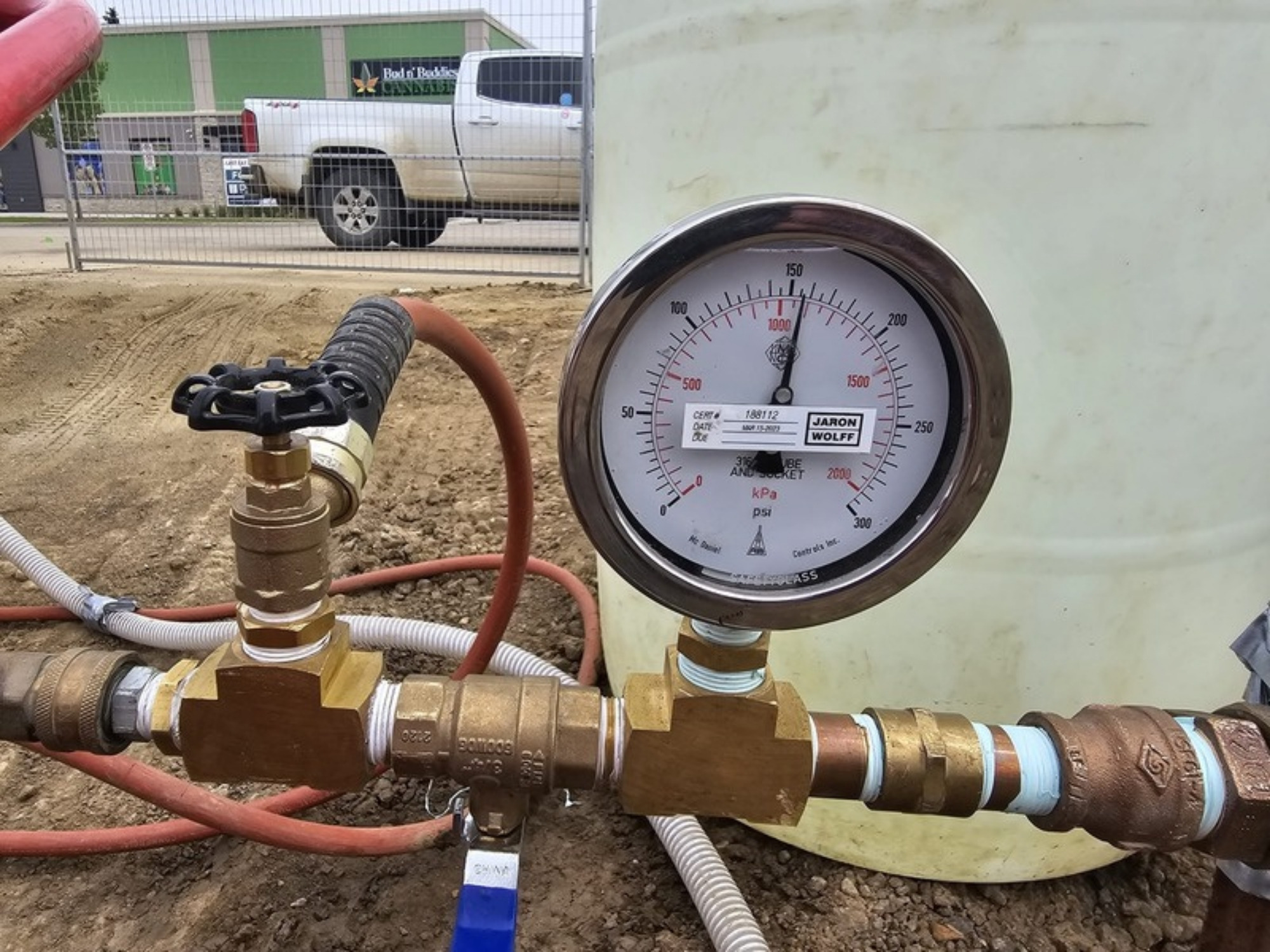 Pressure gauge mounted on a brass test manifold during water main testing